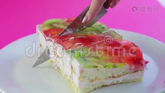 女人手拿刀把水果蛋糕切成块视频