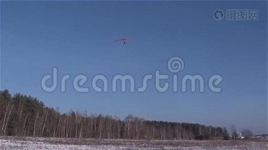 一架悬挂式滑翔机降落在白雪覆盖的草地上视频