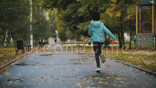 雨天在秋天公园散步的漂亮女孩。视频