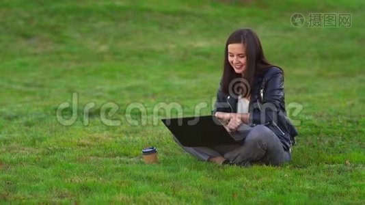 公园里的小女孩带着笔记本电脑。 在视频通话中交谈。视频