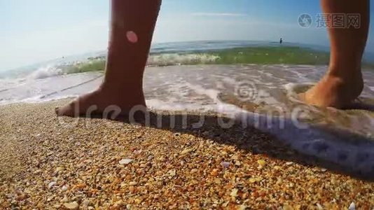 女性的腿沿着海岸行走，留下痕迹视频