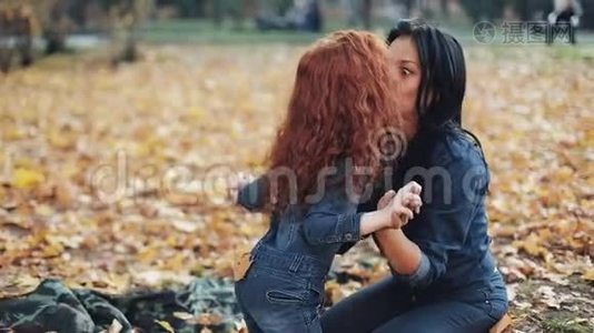 小红发女孩和妈妈一起在秋天公园度过时光。 他们玩，拥抱，玩得开心视频