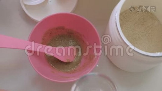 藻类抗衰老面膜的制备。 专业美容师将配料混合在粉红色的杯子里。 健康和美丽。 特写镜头。视频