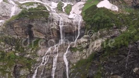 空中观景无人机拍摄到几条瀑布从陡峭的大山岩上流下来，这些岩石被郁郁葱葱地包围着视频