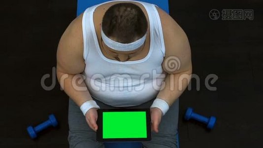 超重男性滚动片坐在垫子上，饮食专家在线咨询视频