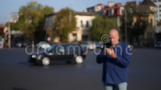 男子在市中心的大街上行走，用手机发短信视频