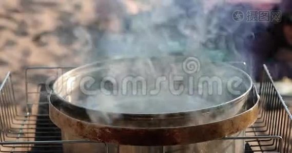 大锅里的水在木桩上加热视频