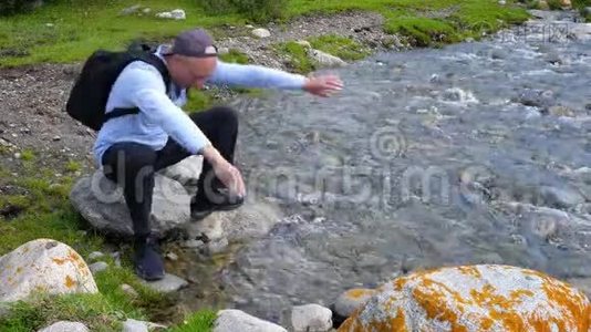 人在山谷的石河岸边被冷水洗脸视频