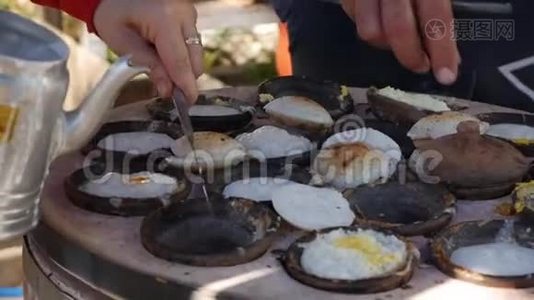 越南街头美食。 供应商准备的面包罐是一种带有鸡蛋的米饼，越南著名的菜肴，蛋糕的加工过程从视频