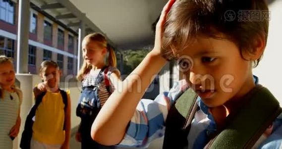小学生们在小学走廊里欺负一个悲伤的男孩视频