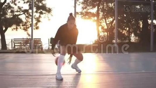 特写镜头，一个年轻的女孩篮球运动员训练和户外运动的地方法院。年轻女子视频