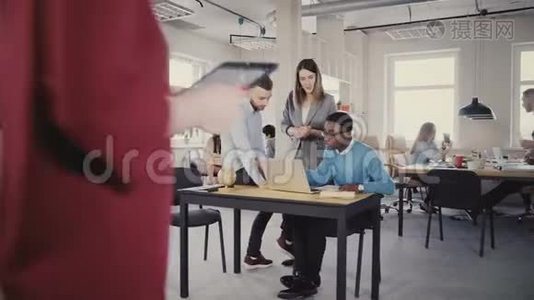 自信的女性CEO帮助混合种族的男性同事，看着笔记本电脑屏幕。 现代办公室4K的团队合作。视频