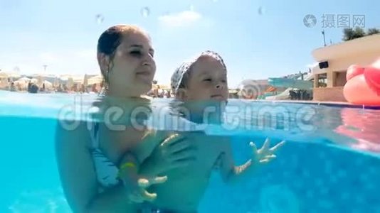 阳光明媚的日子里，妈妈带着儿子在游泳池游泳，欢快的水下动作视频视频