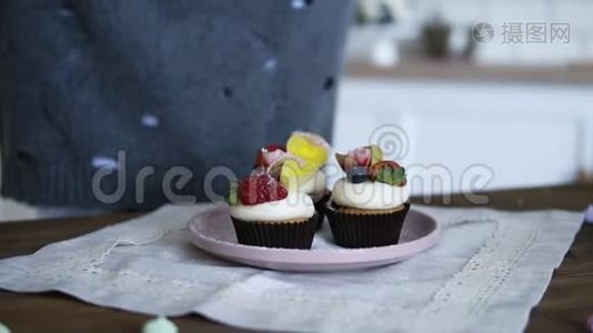 糖果装饰美味，花哨装饰的纸杯蛋糕。 在蛋糕上撒上新鲜的草莓和糖视频