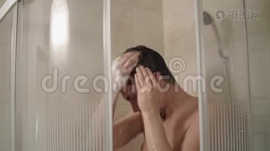 一个年轻人在浴室里用洗发水彻底洗头视频