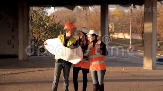 建筑工人和女建筑师审查和讨论建造一个新的购物中心的计划，测量视频