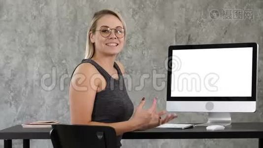 商务女士在办公室里和摄像机对着电脑屏幕说话。 白色显示器。视频