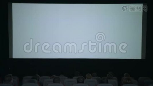 电影院里的白色大屏幕。 在电影院开始拍电影。 电影院放映观众视频