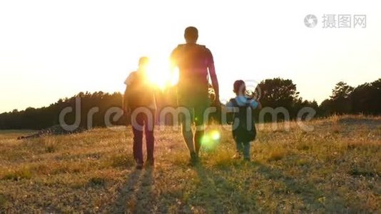 一个快乐的游客家庭：爸爸和他的两个儿子带着背包在大自然中行走。 旅游的概念视频