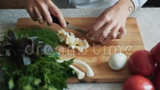 用刀子把煮好的鸡蛋切在木板上，把煮好的手收起来. 食物概念视频