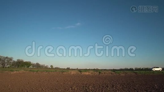 一辆汽车正行驶在经过田野的土路上，有点慢视频