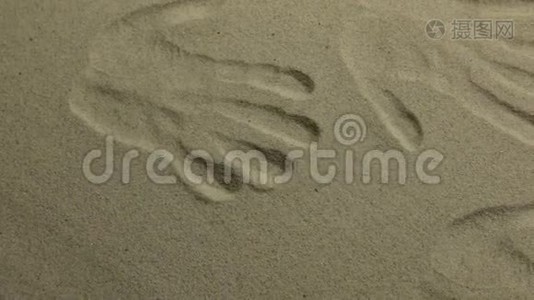 全景。 黄沙中的手印特写..视频