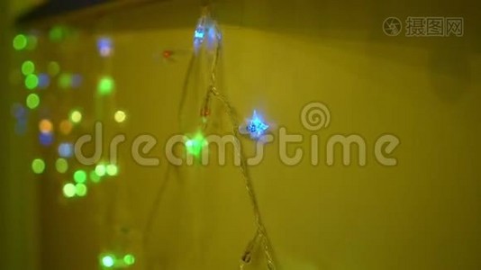 多种颜色的圣诞花环和黄墙背景灯视频