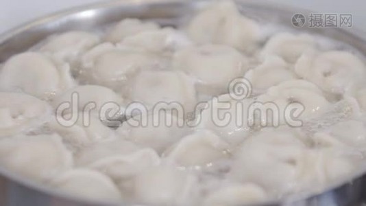 拉维奥利在水中煮沸，香料在锅里。 饺子是俄罗斯传统食品。 食物背景。视频