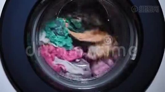 洗衣是在自动洗衣机里洗的，在滚筒里旋转。 洗衣服。 家庭作业视频