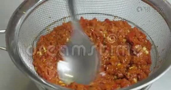 通过蒸煮后的一个筛子过滤均匀的红辣椒质量，得到一个热辣椒酱。 蔬菜炖菜视频