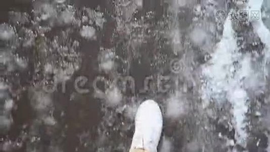 白色运动鞋行走在湿沥青人行道上的雪地POV视频视频