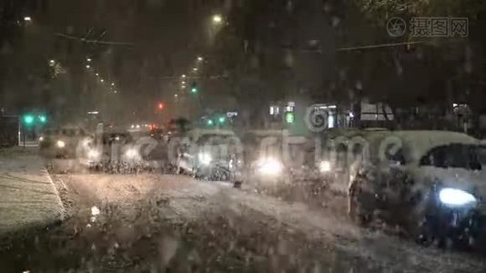 汽车在冬季暴风雨和暴风雪中行驶。 城市里夜里下着大雪。 大雪阻碍了城里的道路交通. 夜晚视频