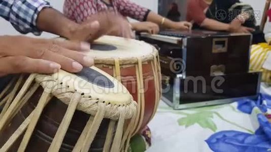近距离拍摄双手演奏印度古典音乐乐器塔布拉和背景中的口琴演奏视频