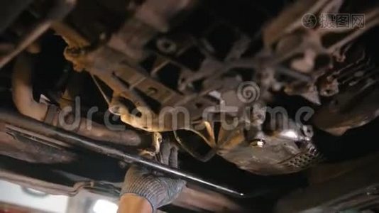 汽车修理店-汽车的下面的部分-男人从污垢中抹去细节视频