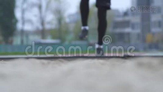 男子脚在沙滩上跳户外跳高腿在沙滩上跳运动场健康生活方式视频