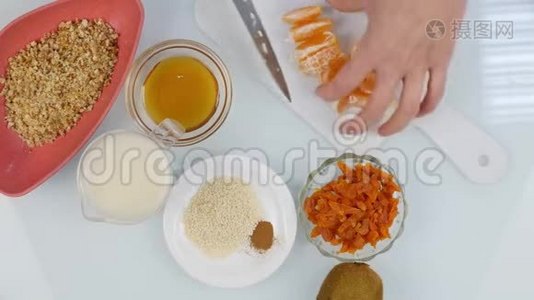 在厨房里，女人`的手切成了水果沙拉的普通话。 烹饪健康的食物。 4K视频