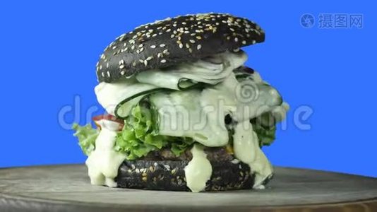 一个多汁的大汉堡，里面有一个绿色的小面包，里面撒着芝麻和青菜，里面还有一块肉馅视频