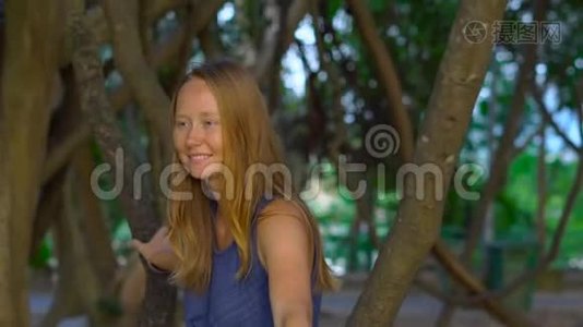 一位年轻女子坐在热带公园里的利亚纳。 托尼卡概念中的假日视频