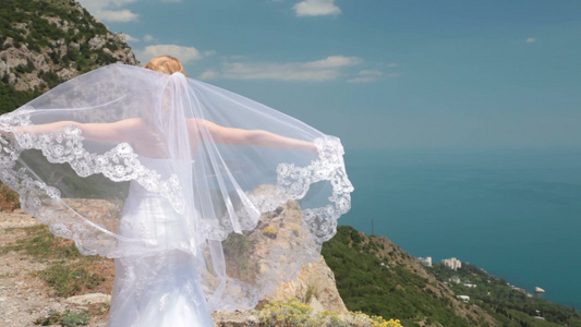 新娘站在悬崖上戴着头纱摆造型视频
