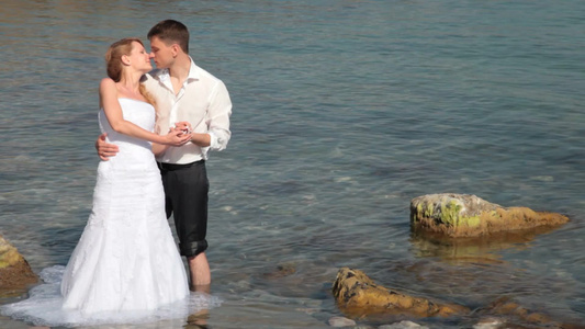 海边拍婚纱照亲吻的新郎新娘视频