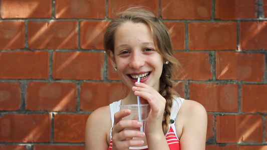 喝着果汁的女孩对镜头微笑[笑意]视频
