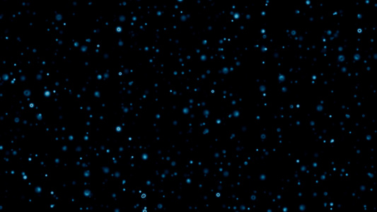 蓝色的粒子慢慢地落在黑暗的背景上视频