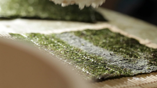 把米饭放在诺丽身上做寿司卷。视频