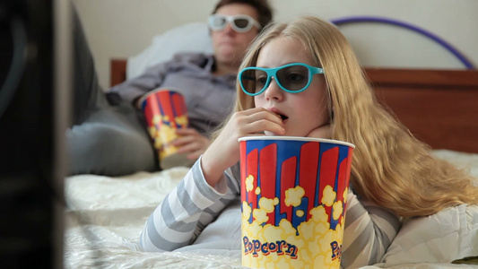 哥哥和姐姐在家吃爆米花看3D电影视频