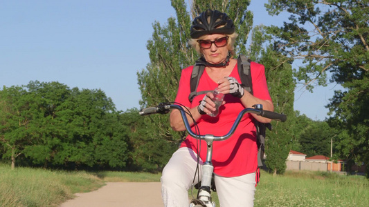 老年妇在乡村小路上骑自行车视频