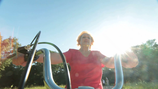蓝天下骑自行车的老年妇女视频