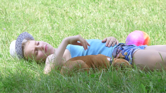 女孩和小狗躺在草地上视频