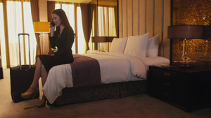 坐在酒店床上电话交谈的女人16秒视频