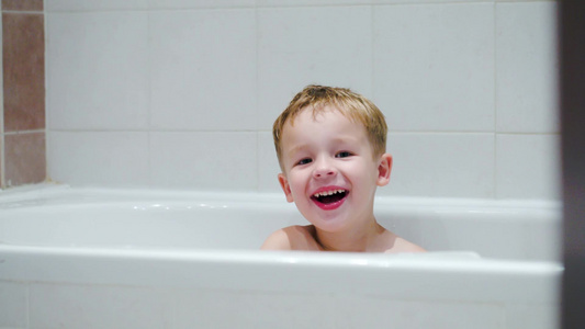 快乐的小男孩坐在浴缸里视频