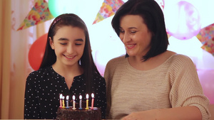 母亲和女儿快乐的吹生日蛋糕蜡烛许愿19秒视频